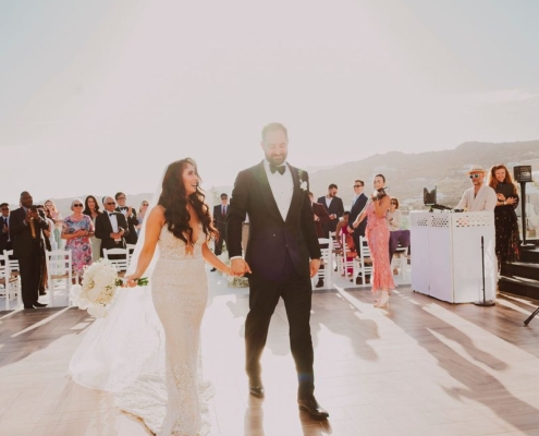 Bride and groom recessional at Royal Myconian, Mykonos – DJ Seitan setup visible Τραγούδι ζευγαριού γάμου – Wedding Jockey