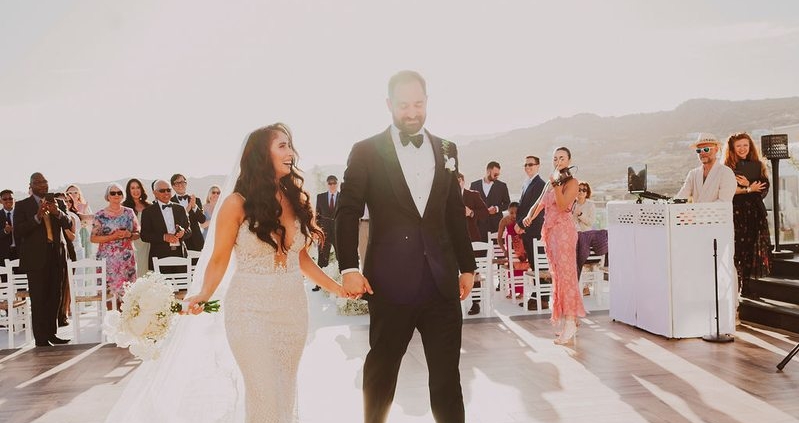 Bride and groom recessional at Royal Myconian, Mykonos – DJ Seitan setup visible Τραγούδι ζευγαριού γάμου – Wedding Jockey
