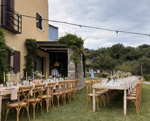 Outdoor wedding dinner tables set up at Chara Houses, Mani, with string lights and colourful candles