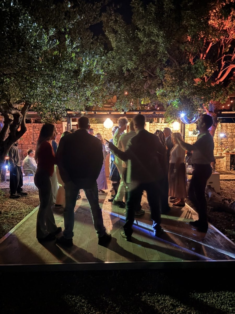 Wedding dance floor at night, Chara Houses, Mani – guests dancing under olive trees with DJ lighting