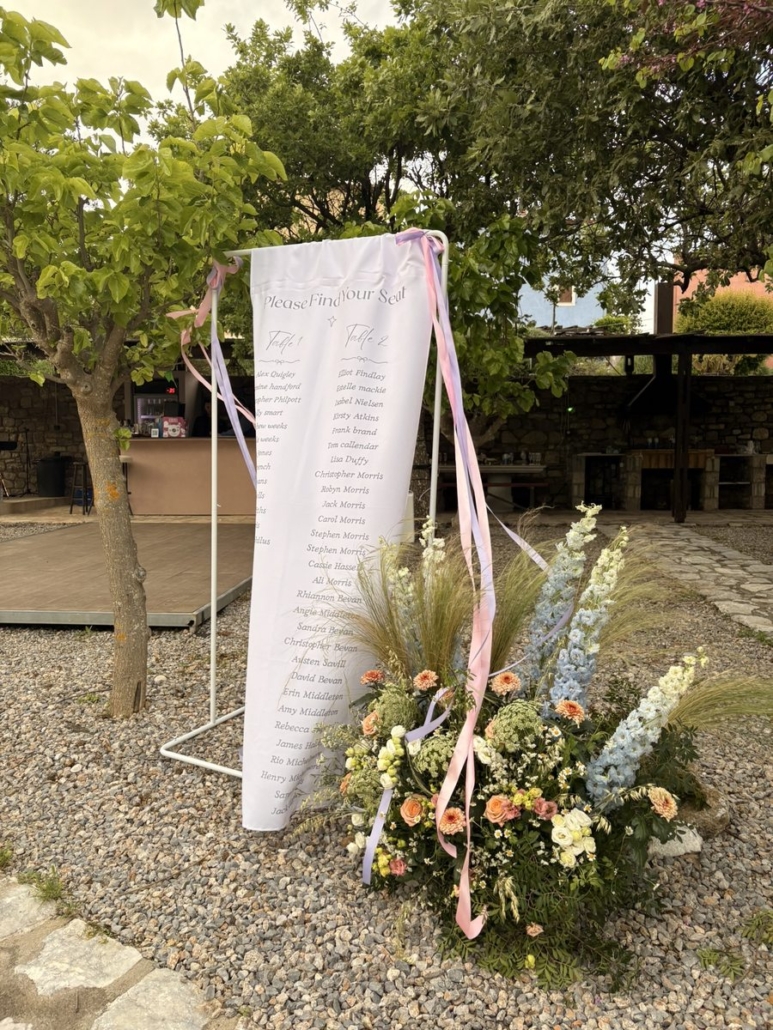 Wedding seating chart banner with floral arrangement at Chara Houses, Mani